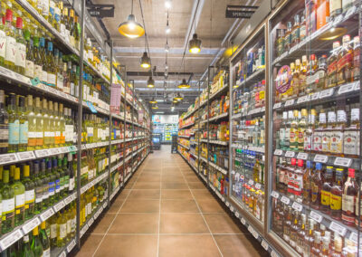 Langer Gang im Supermarkt mit dicht bestückten Regalen voller Wein und Spirituosen auf beiden Seiten.